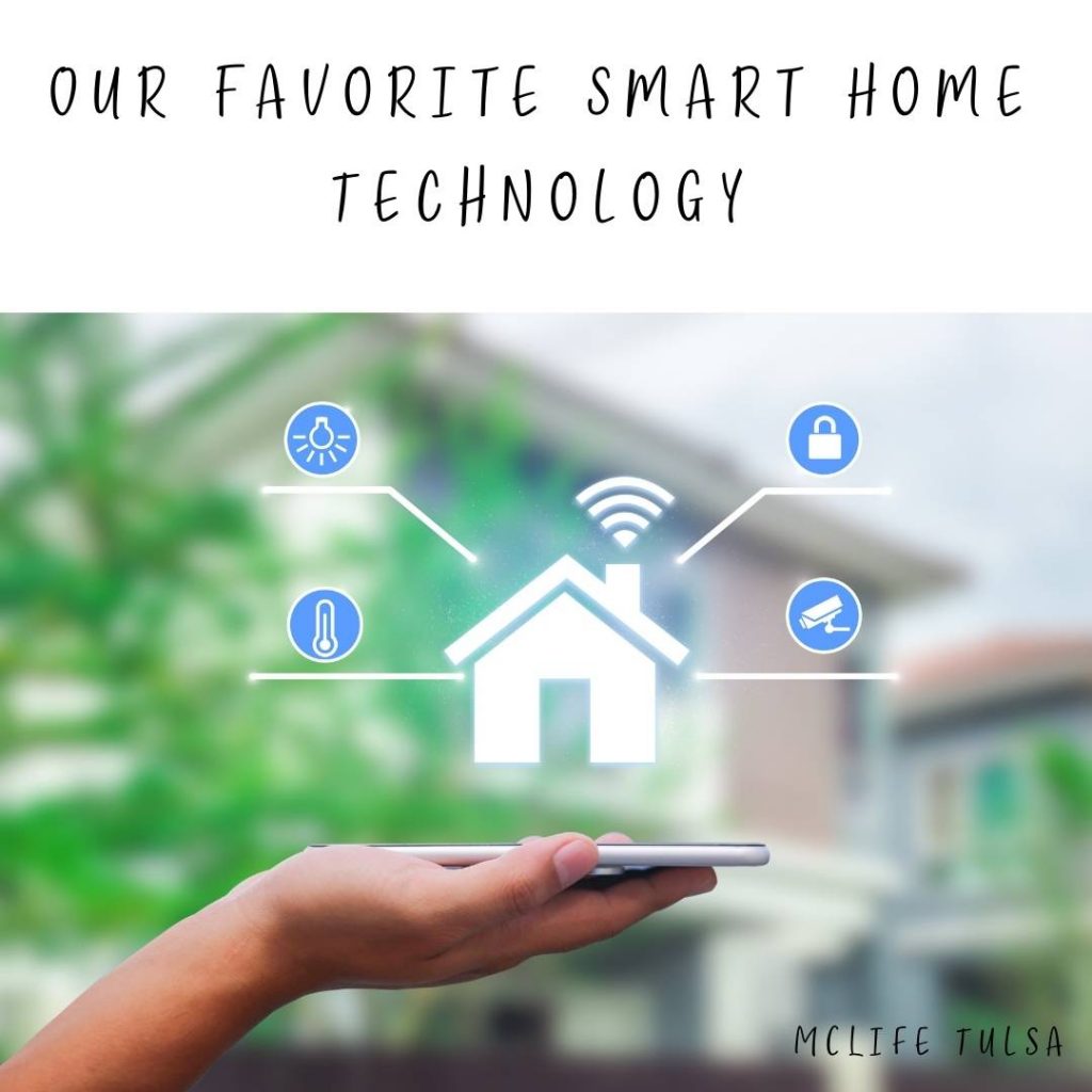 Image of person holding a cell phone in front of a two story home. There are images of icons that show all the different technological advances in a house today.