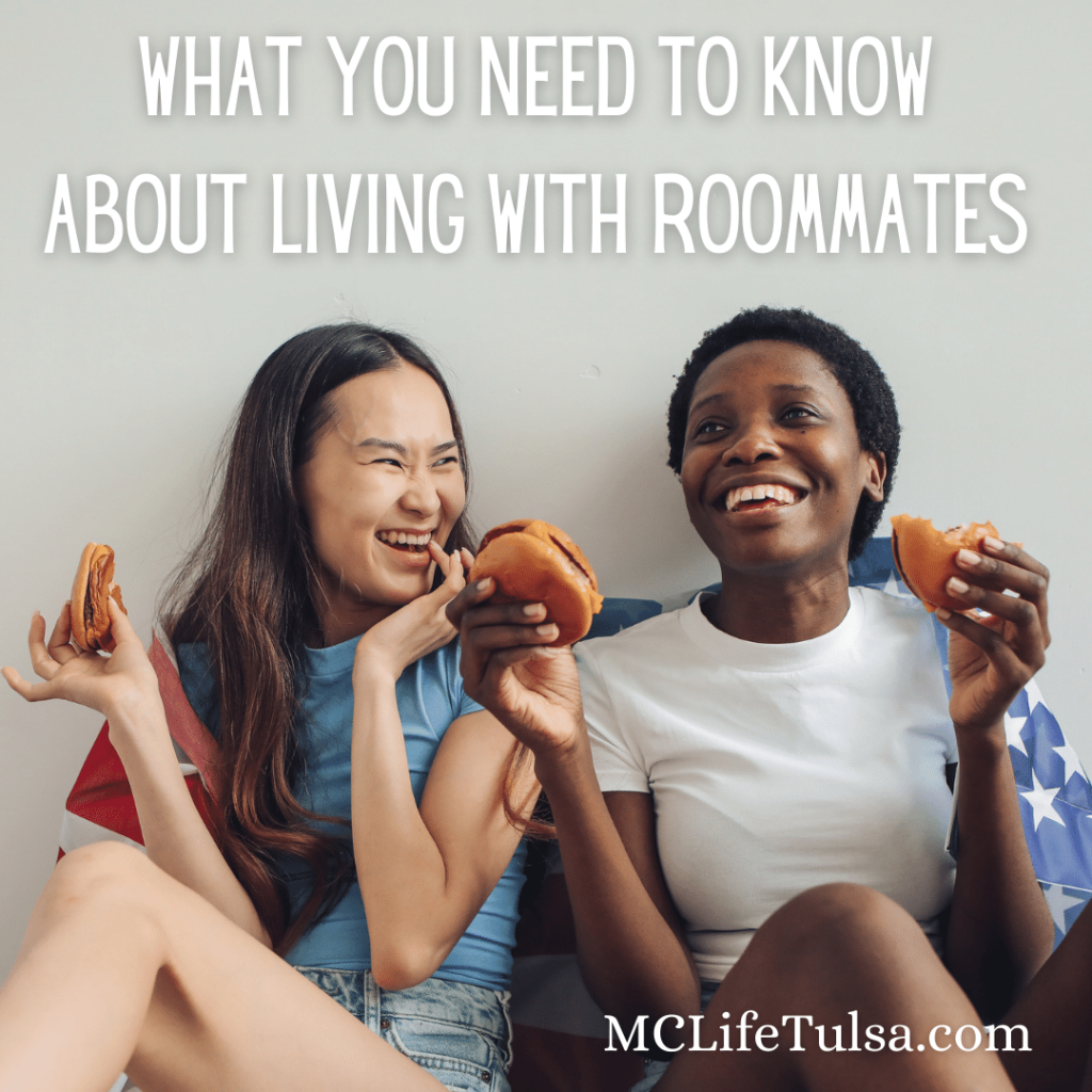 Image of two young adults sitting on the floor and eating cheeseburgers. 