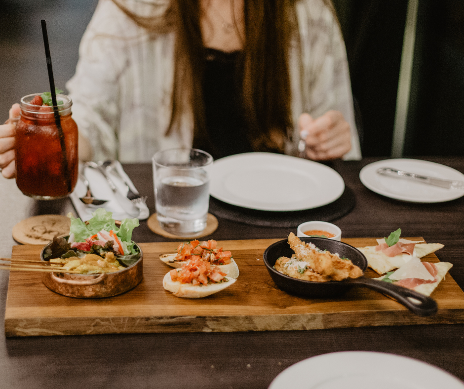 a view of a restaurant table with diner holding up a glass of soda